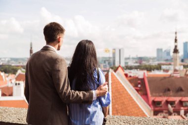 Şehre bakan mutlu çiftin arka görünümü