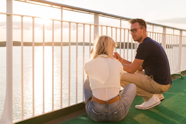 The young happy couple sitting on the ship against the background of the sea