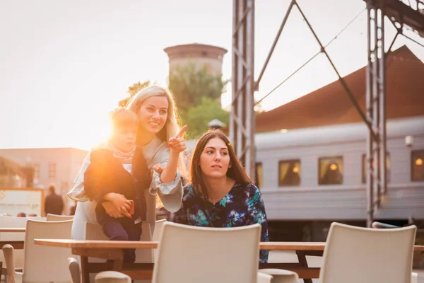 Δύο Ευτυχισμένες Νεαρές Γυναίκες Κάθονται Στο Σταθμό Χαριτωμένο Αγοράκι Και — Φωτογραφία Αρχείου