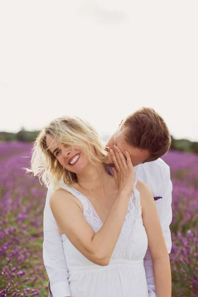 若い男キス彼の笑顔妊娠中の妻でラベンダー畑 — ストック写真