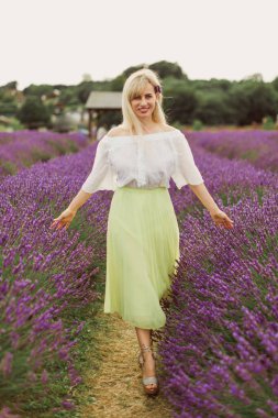 Güzel sarışın lavanta tarlasında yürüyor