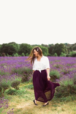 Genç esmer, lavanta tarlasında yürüyor.