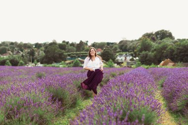 Neşeli genç esmer lavanta tarlasında koşuyor.