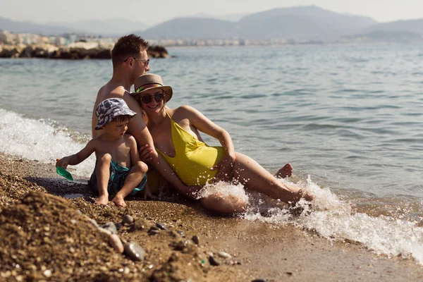 Den Glada Unga Gravida Familjen Sitter Vid Havet Och Svalkar — Stockfoto