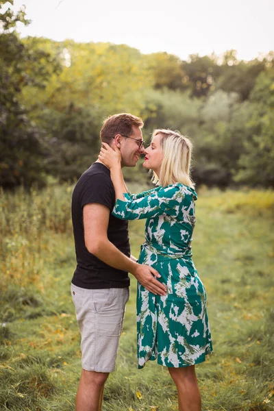 庭の幸せな妊娠中のカップルの側面図 — ストック写真