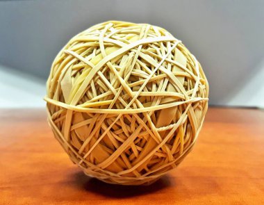 Görüntüdeki gri bir arka plan ile ahşap bir masaya oturan merkezli lastik topu.