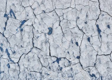 Eski bir boyalı işaret bir park yerinde boya altında göstermeye başlayan mavi boya ile kırık. Çürüme belirtileri.