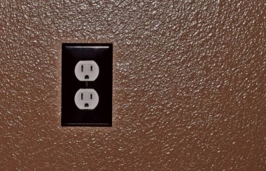 Merkezi kapalı görüntüsünü bir kahverengi dokulu duvar için sabit bir elektrik prizi.