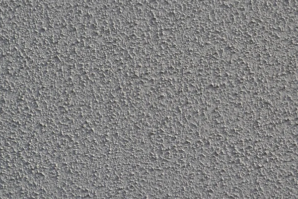 Rough texture of white paint on an exterior wall.
