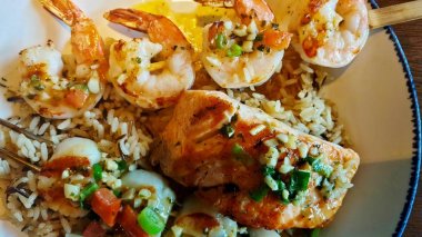 Balık, şiş karides, pirinç ve garnitür ile karışık deniz ürünleri çanak yakın çekim doğrudan yukarıdan görüldüğü gibi.