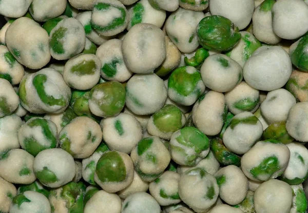 Macro image of Wasabi Peas, a hot salty snack of roasted, dehydrated peas and other lesser ingredients including fiery Wasabi. They have fiber and other nutritional benefits but a fairly high calorie count.