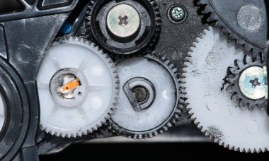 Bir yazıcı kartuşundan mürekkep lekeli plastik dişli jantların ve vidaların ve diğer bileşenlerin görünümünü yakın.