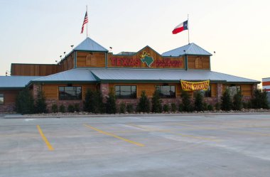 Houston, Texas/Usa 09/06/2019: Texas Roadhouse et lokantası, ön tarafta bir işe alım tabelası ile Humble, Tx'te yeni bir açılış için hazırlanıyor. Çatıda bayraklar ile ön planda otopark.