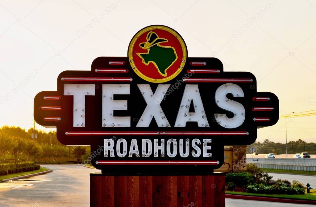 Houston, Texas/USA 09/06/2019: Texas Roadhouse restaurant sign on the side of a freeway in Humble, Texas during an early morning sunrise.
