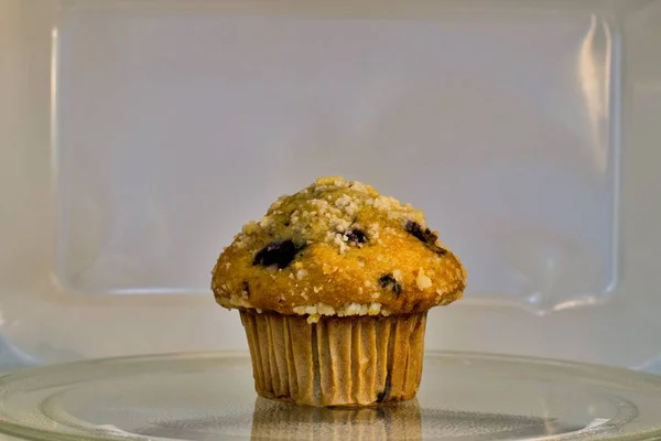 Jeden Borůvkový Muffin Sedí Uprostřed Mikrovlnného Kolotoče Bílé Pozadí Interiéru — Stock fotografie