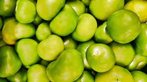 Tomatillos fruits piled together for sale at a market. Popular in the Americas and Mexico, they are used to make salsa and green sauces.