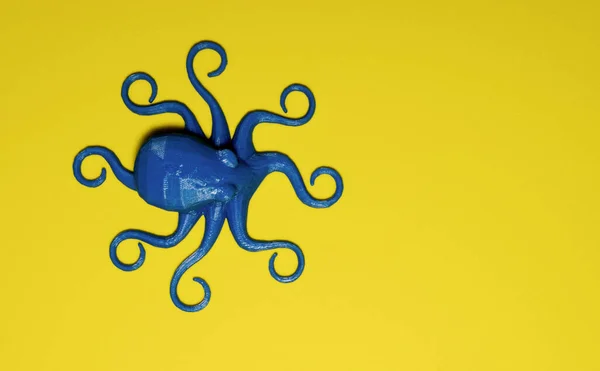 Blue plastic toy octopus on plain yellow background with copy space. They symbolize intelligence, flexibility, emotions, logic, creativity and potential.