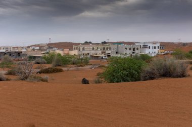 Ras al Khaimah, Birleşik Arap Emirlikleri turuncu kum tepeleri tarafından çevrili konut alanı üzerinde Thunder bulutlar.