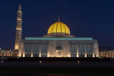 Muscat, Umman kapalı parlak sarı gösteren kubbe gün batımında Sultan Qaboos Ulu Camii.