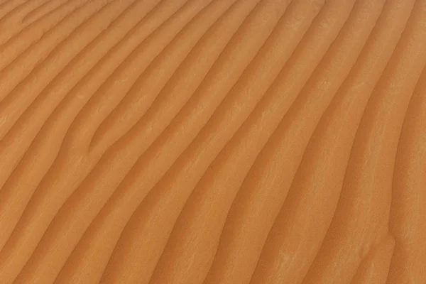 アラブ首長国の美しい太陽の光で波打つ砂丘テクスチャ背景のデザイン — ストック写真