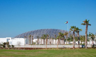 The Abu Dhabi Louvre is an impressive museum inside and out. Beautiful blue sky exterior with grass and flag clipart