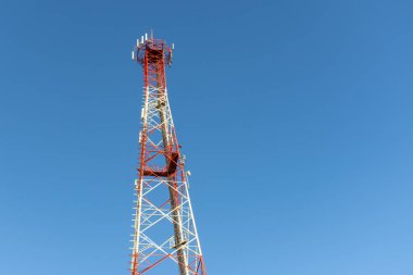 Bir kırmızı ve beyaz cep telefonu veya cep telefonu telekomünikasyon kulesi üzerinde