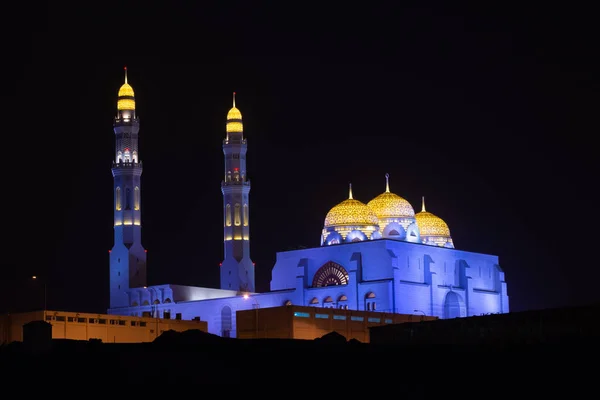 Al Ameen City Mosque glowing at night purple and yellow in Muscat — Stock Photo, Image