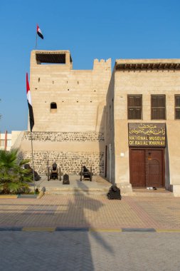 Bayraklar üfleme ile sabah güneşinde Ras al Khaimah Müzesi girişinin portre görünümü.