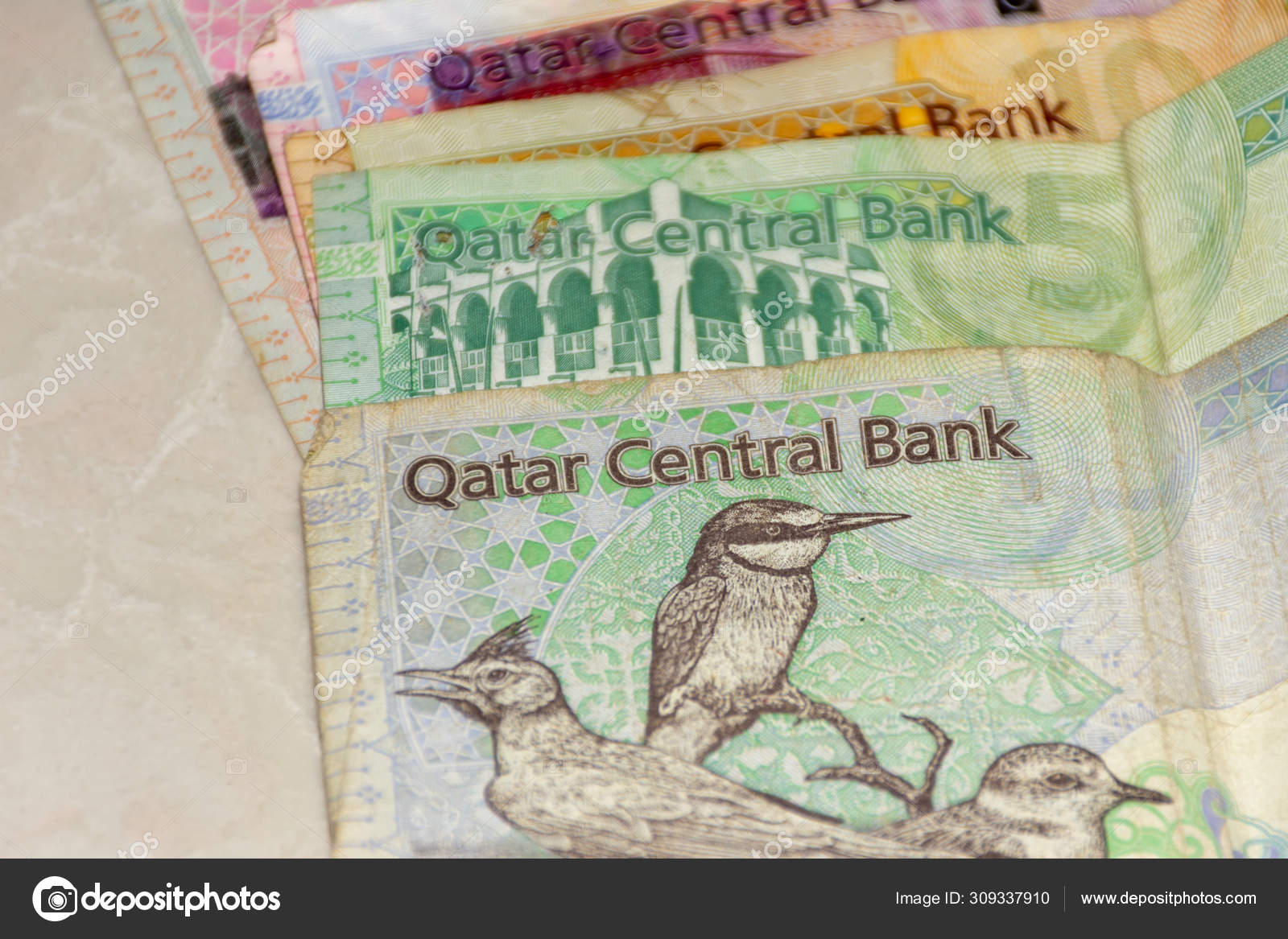 白色背景上分布着卡塔尔货币或卡塔尔里亚尔现金纸币的特写。货币兑换. ——图库图片© kingmaphotos@gmail.com #309337910