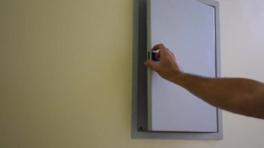 Bir konuttaki sigorta kutusunu açıp elektrik kesicilere bakıyor. Elektrik kesintisini onarıyor..