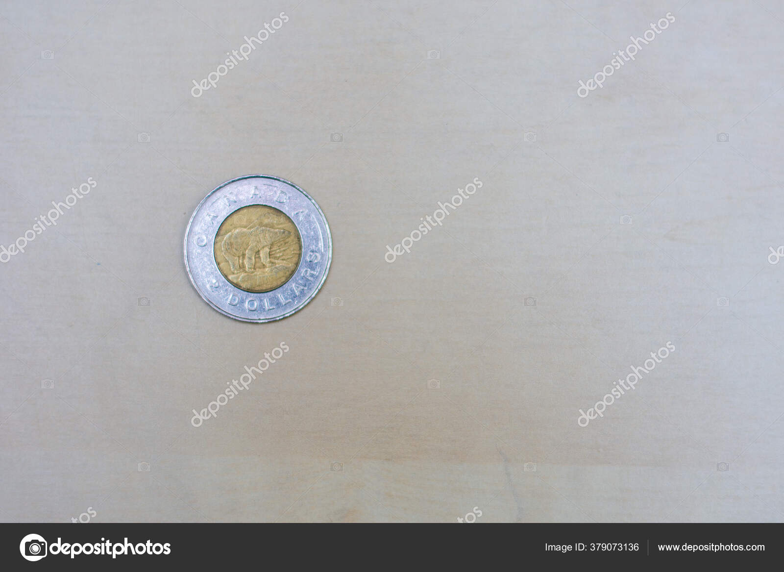 金币一种图尼币或两美元硬币加拿大货币背景为浅褐色有复制空间货币兑换——图库图片© kingmaphotos@gmail.com #379073136