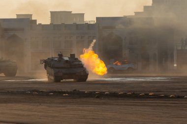 Askeri patlama, çatışma, savaş ve kaos. Tanklar duman ve yıkımın içinden geçiyor. Askeri kavram.
