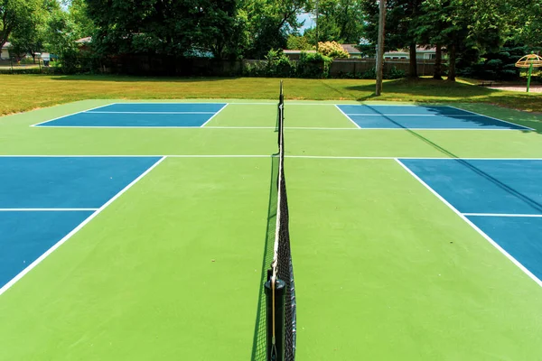 피클볼 코트에서 열리는 레크리에이션 스포츠는 공원에서 열리는 파란색과 녹색의 법원을 — 스톡 사진