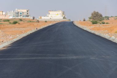 Çöl kumunda arabasız ve insansız yeni bir yol. Sözleşme, ıssız, sıcak, kurak kavramlar.