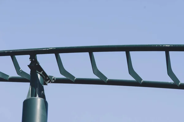 テーマパークや遊園地でジェットコースターの閉鎖空の緑の金属のトラックと青空の背景に — ストック写真