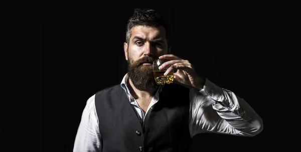 Dégustation, dégustation. Un homme barbu tient un verre de brandy. Concept dégustation et dégustation. Homme d'affaires barbu en costume élégant avec un verre de whisky. Sommelier goûte boisson chère — Photo