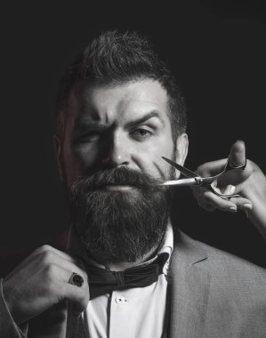 Sakallı adam, uzun sakallı, acımasız, beyaz hipster bıyıklı. Erkekler saçlarını kuaför dükkanında. Kuaför makası, ustura, berber dükkanı. Erkek saç kesimi, tıraş. Erkek Berber Dükkanı '. Siyah ve beyaz