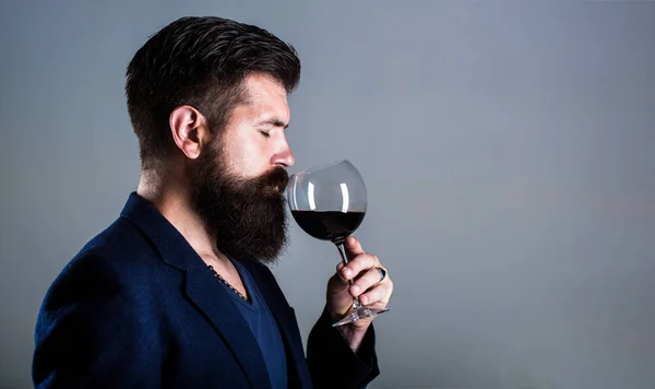 Sommelier, dégustateur avec verre de vin rouge, cave, vigneron masculin. Homme barbu, barbu, sommelier dégustant du vin rouge. Homme avec un verre de vin dans les mains — Photo