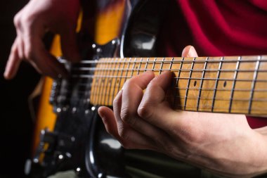 Gitar, dize, gitarist, müzisyen rock. Müzik aleti. Elektro gitar, rock konseri. Gitarist çal, müzik donanımları. Alet üstünde sahne ve müzik grubu. Canlı müzik. Gitar ve yaylı, performe