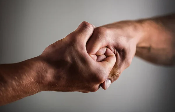 Male hand united in handshake. Man help hands, guardianship, protection. Two hands, isolated arm, helping hand of a friend. Handshake, arms. Friendly handshake, friends greeting. Rescue, helping hand
