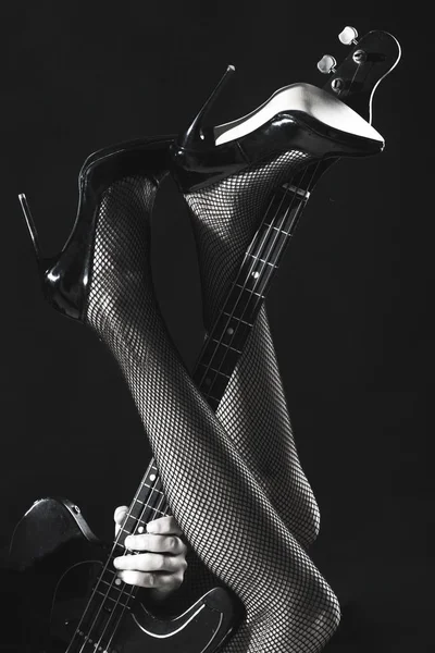 Sexy legs, long legs on high heels, shoes. Instrument on stage and band. Electric guitar, bass-guitar, play the guitar. Leg in shoes. Sexy woman. Black and white — Stock Photo, Image