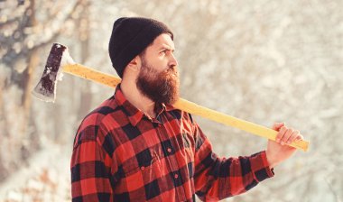 Sakallı bir oduncu portresi. Oduncu balta ile ormanda. Bir balta ile şapkalı sakallı adam. Yakışıklı adam. Oduncu acımasız sakallı adam sakal, bıyık kış gününde, karlı orman ile