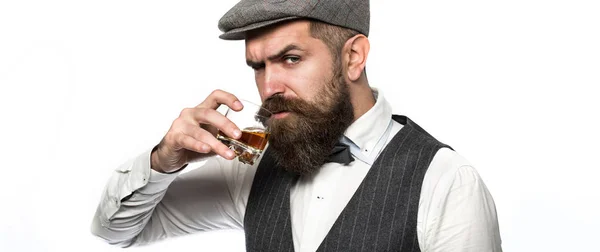 Sommelier are gust de băutură scumpă. Frumos om bine îmbrăcat în jachetă cu pahar de băutură. Bărbat cu barbă care poartă costum şi bea whisky, coniac, coniac. Barba ţine un pahar de whisky. — Fotografie, imagine de stoc