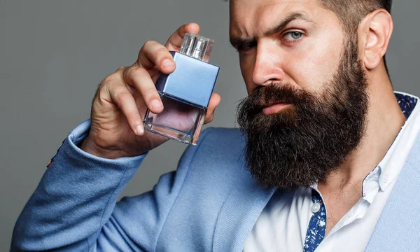 Bouteille d'eau de Cologne mode. Homme barbu préfère odeur de parfum cher. Parfum d'homme, parfum. Parfum masculin et parfumerie, cosmétiques. Parfum masculin. Homme barbu tenant une bouteille de parfum — Photo