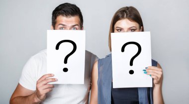 Anonymous, erkek ve kadın soru. Sorunlar ve çözümleri. Yanıt almaya. Holding kağıt soru işareti çift portresi. Çift kavga. İnsanlar arasında kavga. Sorun çift, soru işareti