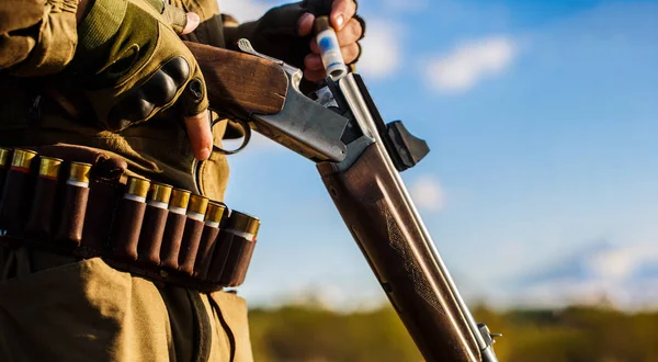 Hombre cazador. Periodo de caza. Hombre con un arma, rifle. El hombre está cargando un rifle de caza. Proceso de caza durante la temporada de caza. Hombre cazador listo para cazar. Primer plano. El hombre está en la caza, el deporte — Foto de Stock