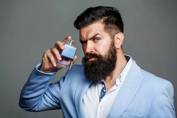 Parfum d'homme, parfum. Parfum masculin. Parfum masculin et parfumerie, cosmétiques. Homme barbu tenant une bouteille de parfum. Bouteille d'eau de Cologne mode. Barbu mâle préfère parfum cher odeur — Photo