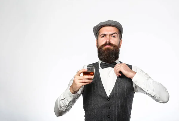 Γενειοφόρος σε είναι κρατώντας ένα ποτήρι ουίσκι. Σομελιέ γεύσεις ακριβό ποτό. Όμορφος καλοντυμένος άνδρας στο σακάκι με το ποτήρι του ποτού. Γενειοφόρος άνδρας φοράει κοστούμι και πίνοντας ουίσκι, κονιάκ, κονιάκ — Φωτογραφία Αρχείου