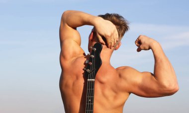 Gitar çalmak. Elektro gitar. Güzel gövde olan adam. Sağlık, atletik beyaz, kas. Adam arka, kaslı adam, sırt kasları, kas arka spor salonu, güçlü sırt. Seksi Anne