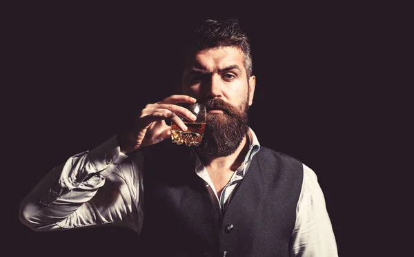 Portrait of man with thick beard. Macho drinking. Stylish rich man holding a glass of old whisky. Bearded gentleman drink cognac. Sipping finest whiskey